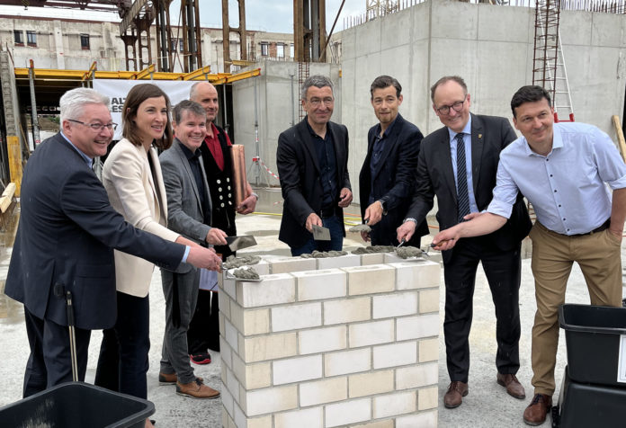 Grundsteinlegung_Gesamt Sie griffen bei der Grundsteinlegung gemeinsam zum Hammer: Sven Mai, Projektleiter Halle 12 und Prokurist WEP-Gruppe, Vicki Felthaus, Bürgermeisterin und Beigeordnete für Jugend, Schule und Demokratie, Kai Thalmann, Geschäftsführer Leipziger Entwicklungs- und Vermarktungsgesellschaft mbH & Co. Grundstücks-KG, Matthias Kaufmann, Polier Köster GmbH, Thomas Dienberg, Bürgermeister und Beigeordneter für Stadtentwicklung und Bau, Wolfram Mohr, Architekt S&P Sahlmann Planungsgesellschaft für Bauwesen mbH Leipzig, Ulrich Hörning, Bürgermeister und Beigeordneter für Allgemeine Verwaltung und Thomas Kirmse, Geschäftsführer WEP-Gruppe.
