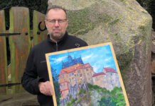 Uwe Gerschler zeigt in der Hospitalkapelle in Grimma Ölgemälde über Bauwerke aus der Region. Foto: privat