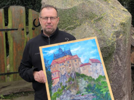 Uwe Gerschler zeigt in der Hospitalkapelle in Grimma &Ouml;lgem&auml;lde &uuml;ber Bauwerke aus der Region. Foto: privat
