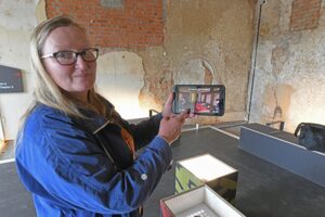 Museologin und Kuratorin Regina Thiede zeigt die Funktionsweise des Tablet-Guide „HistoPad“ in den neu zugänglichen Schlossräumen. Foto: Thomas Kube