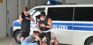 Schülerinnen und Schüler beim Anlegen der Körperschutzausstattung. Gegenseitige Hilfe und Unterstützung sind gefragt. Foto: Bundespolizei