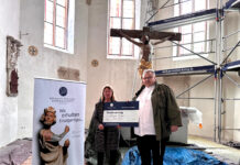 Angelika Dörrscheidt von der Deutschen Stiftung Denkmalschutz überreicht Pfarrer Matthias Taatz in der Kirche zu Brinnis den symbolischen Fördervertrag. Foto: Stephanie Bechert