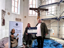 Angelika D&ouml;rrscheidt von der Deutschen Stiftung Denkmalschutz &uuml;berreicht Pfarrer Matthias Taatz in der Kirche zu Brinnis den symbolischen F&ouml;rdervertrag. Foto: Stephanie Bechert