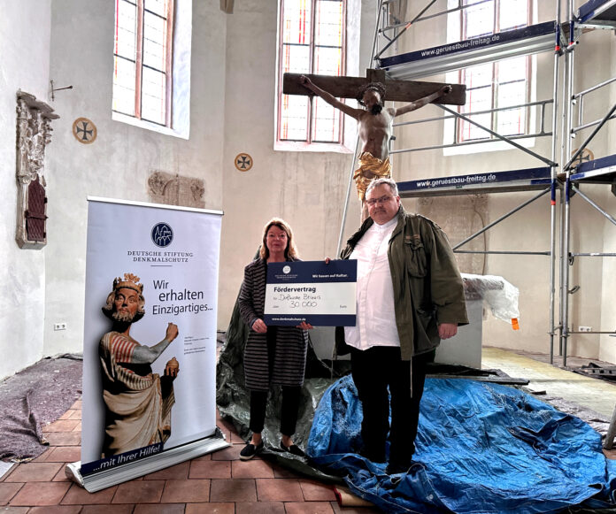 brinnis-dsd-190624 Angelika Dörrscheidt von der Deutschen Stiftung Denkmalschutz überreicht Pfarrer Matthias Taatz in der Kirche zu Brinnis den symbolischen Fördervertrag. Foto: Stephanie Bechert