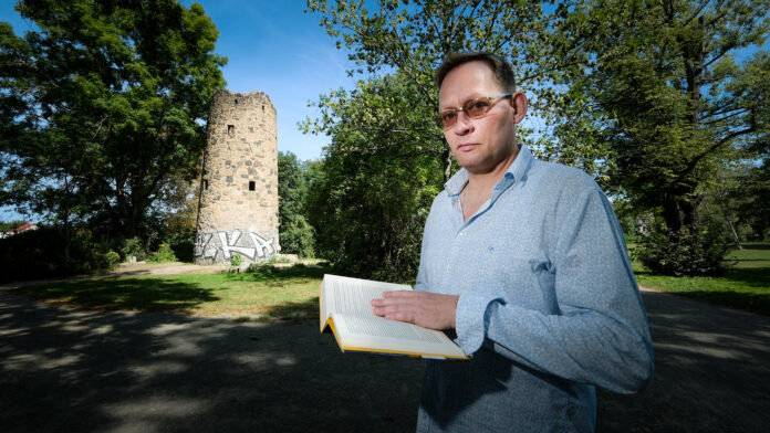 Clemens Meyer, Leipziger Schriftsteller Der Leipziger Schriftsteller Clemens Meyer Im Güntz-Park in Leipzig Stötteritz. Im Hintergrund der Günz Turm, ein Überrest der Irren-, Heil- und Pflegeanstalt, die der Psychiater Günz im 19. Jahrhundert an diesem Ort betrieb. Im ersten Kapitel seines neuesten Buches spielt der Irrenarzt Güntz eine wichtige Rolle. Foto: Wolfgang Sens