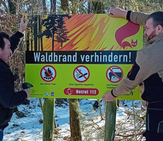 Die Forstwirte Uwe Funke und Matthias Horn beim Anbringen eines neuen Warnschildes bei Taura. Foto: LRA/Bachmann