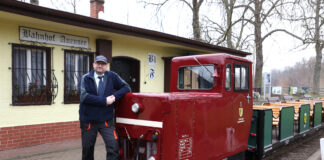 Parkeisenbahn-Chef Jürgen Braun mit der kleinen roten Elektro-Lok, die seit 30 Jahren im Dienst ist. Foto: André Kempner