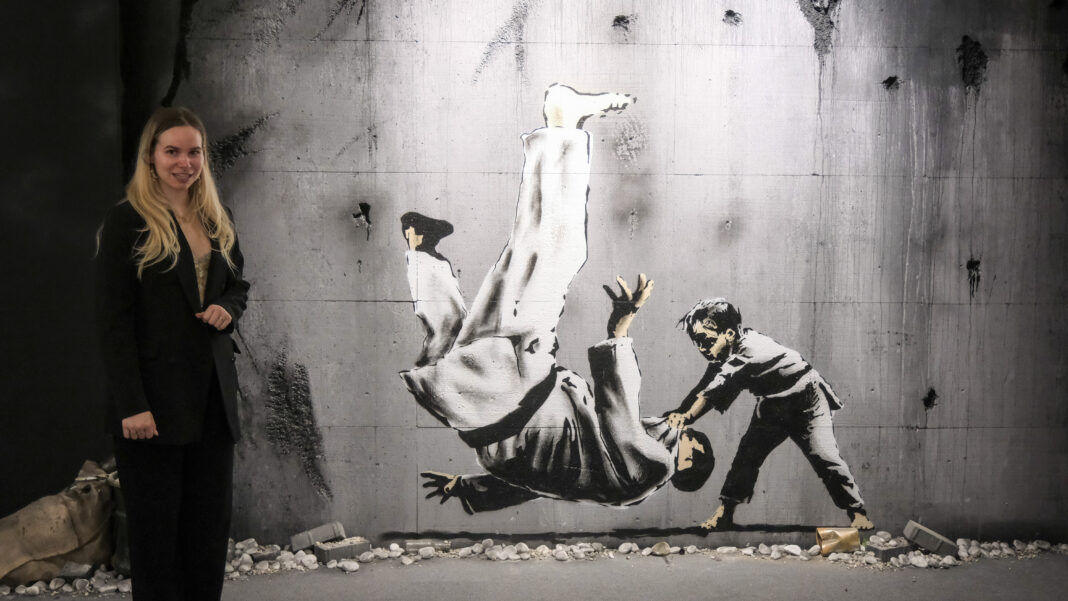 Streetart im geschützen Raum: Eröffnung Pop-Up-Ausstellung „ Ein Kind aus der Ukraine wirft ein Mann zu Boden. Dieses Street Art Bild wurde auch in der Ukraine hergestellt. Auf 1500 Quadratmetern sind im ehemaligen Esprit-Store über 150 Motive des Grafitti-Künstlers zu sehen. Foto: Wolfgang Sens
