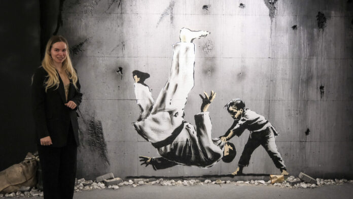 Streetart im geschützen Raum: Eröffnung Pop-Up-Ausstellung „ Ein Kind aus der Ukraine wirft ein Mann zu Boden. Dieses Street Art Bild wurde auch in der Ukraine hergestellt. Auf 1500 Quadratmetern sind im ehemaligen Esprit-Store über 150 Motive des Grafitti-Künstlers zu sehen. Foto: Wolfgang Sens