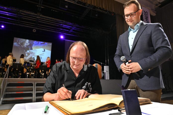 Das Ehrenwappen der Stadt Grimma mit Eintragung ins Ehrenbuch ging an den Stadmusikdirektor a.D. Reiner Rahmlow, rechts Grimmas neuer Oberb&uuml;rgermeister Tino Kie&szlig;ig. Foto: Thomas Kube