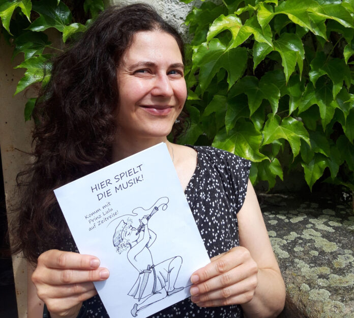 Museumsmitarbeiterin Marlene Hofmann mit dem neuen Sommer-R&auml;tsel. W&auml;hrend ihre Kollegin Franziska Huberty das inhaltliche Konzept schrieb und die Texte vertonte, zeichnete sie Prinz Lulu, schnitt Audios und gestaltete die R&auml;tseltexte. Foto: Burg Posterstein