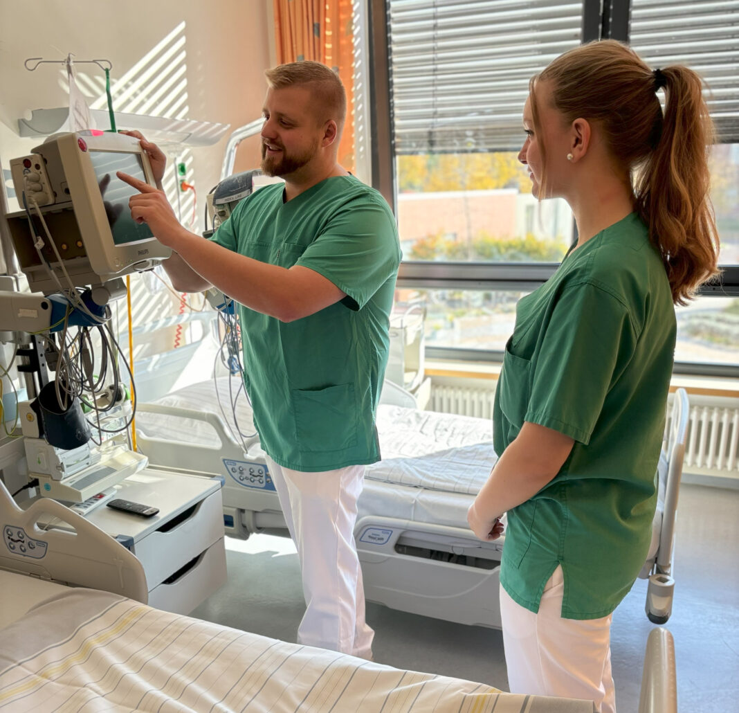 Hauptpraxisanleiter Philipp Teich zeigt einer Auszubildenden, wie man die Vitalzeichen misst. Foto: SKH Altscherbitz