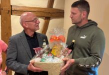 Tom Bauch (r.), Geschäftsführender Vorsitzender des Kreisbauernverbandes Altenburg e.V., übergibt einen Präsentkorb mit Lebensmitteln, die im Altenburger Land ihren Ursprung haben, an Landrat Uwe Melzer (CDU). Foto: Gunter Auer
