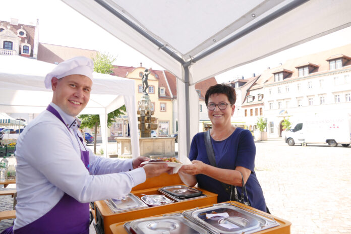 grimma_nimmt_platz_2 Der neue Grimmaer Oberbürgermeister Tino Kießig an der Essenausgabe mit einer Besucherin. Foto: Diakonie Leipziger Land