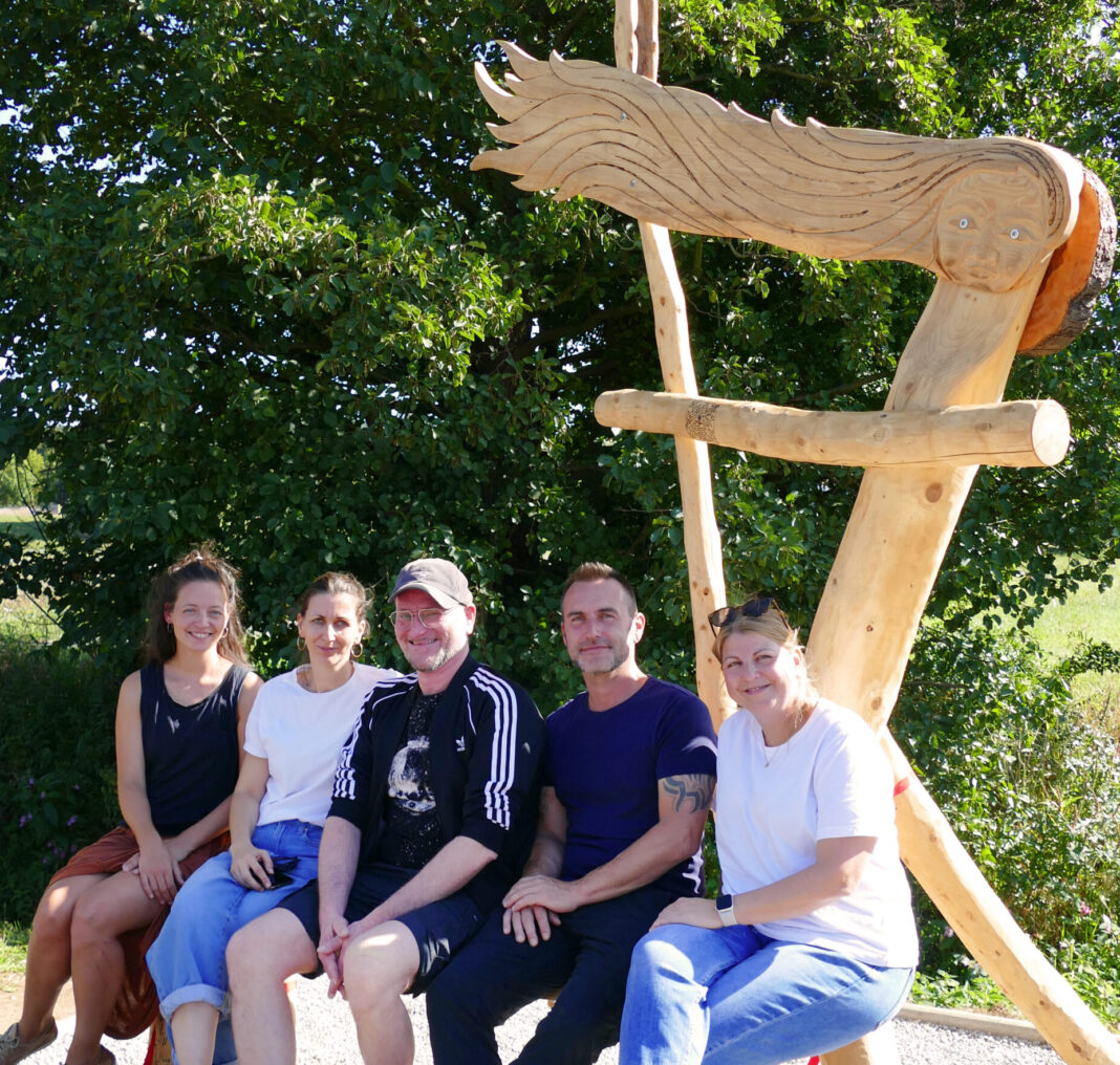 kunstprojekt_team_wws_b Das Team der WaldWerkStatt+ mit der neuen Skulptur mit Bank in Höfgen. Foto: Diakonie Leipziger Land