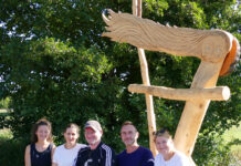 Das Team der WaldWerkStatt+ mit der neuen Skulptur mit Bank in Höfgen. Foto: Diakonie Leipziger Land