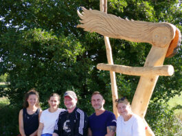 Das Team der WaldWerkStatt+ mit der neuen Skulptur mit Bank in H&ouml;fgen. Foto: Diakonie Leipziger Land