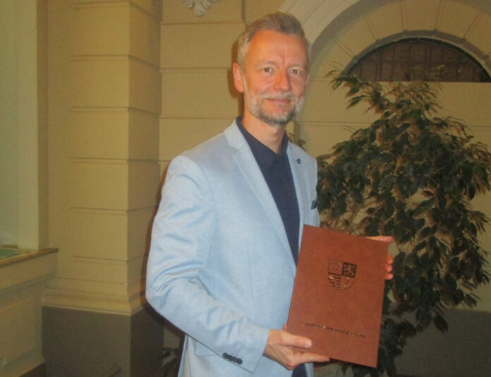 Ehrennadel Alexander Busch bekam die Goldene Ehrennadel des Landkreises überreicht. Foto: Reinhard Weber