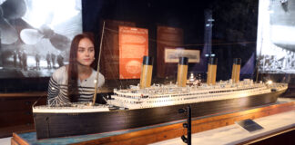 Frau schaut sich Modell der Titanic an