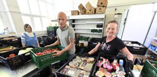 Die Mitarbeiterinnen um Tafel-Leiter Torsten Klose (m.) sortieren flei&szlig;ig die Lebensmittel f&uuml;r die bevorstehende Ausgabe. Foto: Thomas Kube