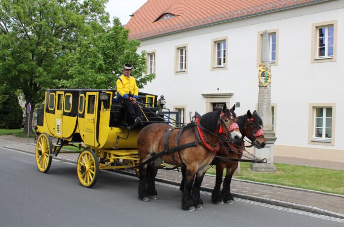 Foto_Postkutsche_2_20MB Die Postkutsche neben der Mügelner Postmeilensäule im Mai 2025. Zum Jubiläumsfest am 3. Mai sollen vier der „Gelben Wagen“ in Mügeln zusammentreffen. Foto: Jan Seelig