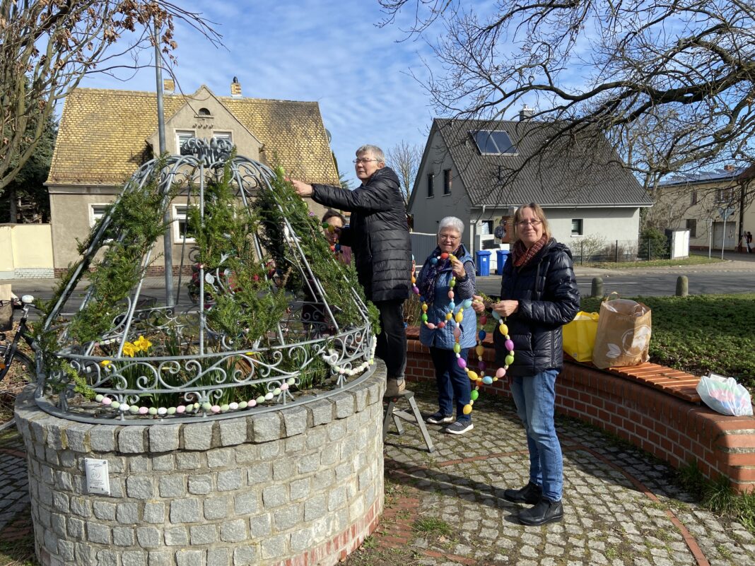 Die Landfrauen aus Schenkenberg schm&uuml;cken den Osterbrunnen an der Hauptstra&szlig;e im Dorf. Foto: Nannette Hoffmann
