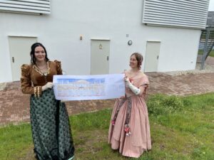 So soll die Seeb&uuml;hne aussehen: Iris Zwiener (li.) und Brit von Ryssel pr&auml;sentieren den Fassadenentwurf, der die Anmutung eines Theaters des 19. Jahrhunderts an den Biedermeierstrand holt. Foto: Nannette Hoffmann 