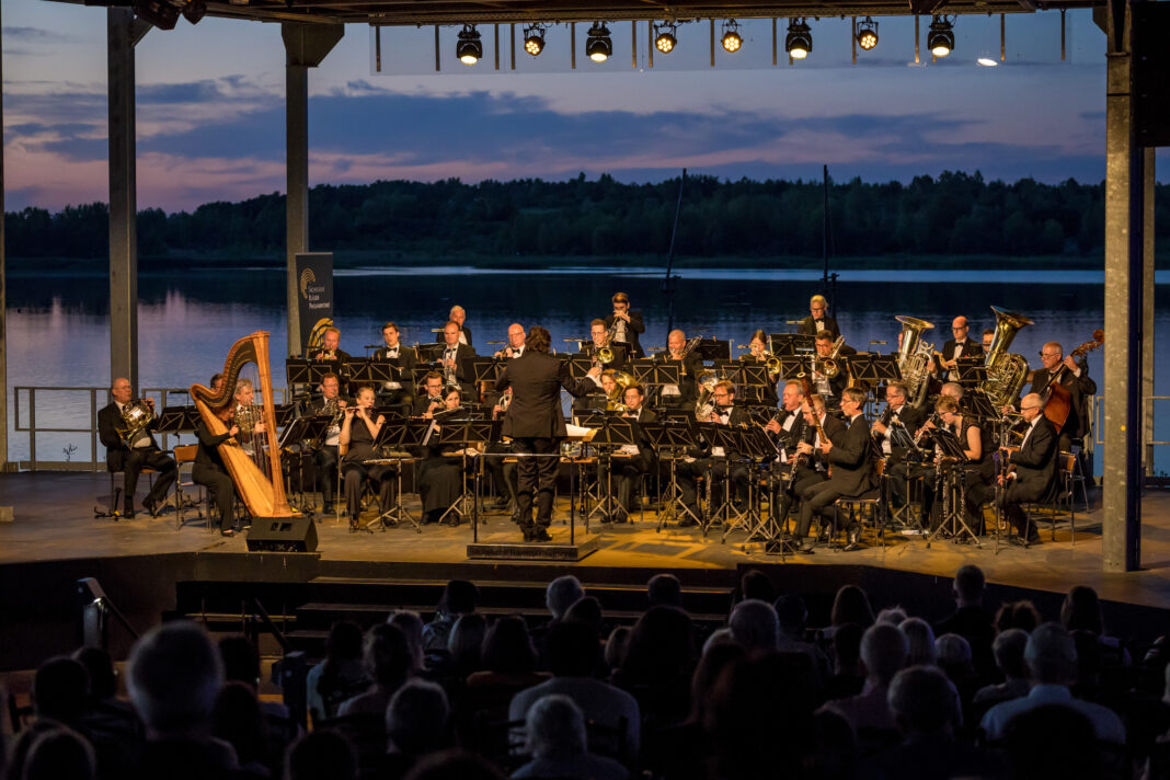 Die S&auml;chsische Bl&auml;serphilharmonie spielt auf der Seeb&uuml;hne am Biedermeierstrand &ndash; mit Sonnenuntergangskulisse. Foto: Maximilian Zwiener