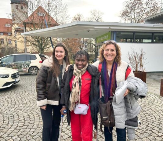 Angelina wird nach ihrer letzten Operation am Haupteingang des Diakonissenkrankenhauses Leipzig von den Friedensdorf-Mitarbeiterinnen Olivia H&ouml;che (l.) und Manuela Rossi in Empfang genommen. Foto: Friedensdorf International