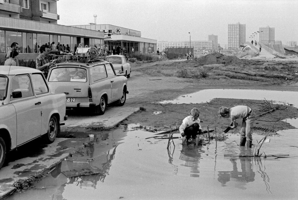 Grünau 1983: Jungen spielen im Schlamm vor einer Konsum-Kaufhalle. Foto: Harald Kirschner