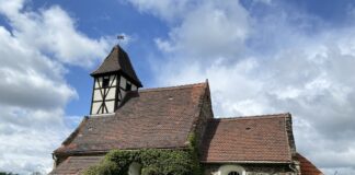 Kleine Feldsteinkirche mit Fachwerkturm: Auf ihrer Anh&ouml;he &uuml;ber Benndorf wirkt die Kirche fast wie eine verwunschene Kirchenburg im Gr&uuml;nen. Foto: Nannette Hoffmann