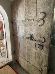 Schwere Holzt&uuml;r aus dem 13. Jahrhundert mit schmiedeeisernenB&auml;ndern: Durch sie betreten Besucher die Zaascher Kirche. Foto: Nannette Hoffmann 