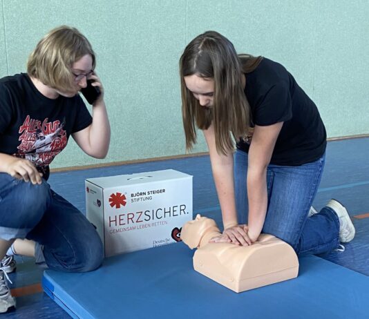 Teamarbeit im Notfall: W&auml;hrend Hannah dr&uuml;ckt, telefoniert Alicia mit der Leitstelle &ndash; so wird der Ablauf einer echten Reanimation geprobt. Foto. Nannette Hoffmann
