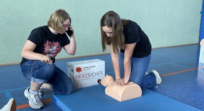 Teamarbeit im Notfall: W&auml;hrend Hannah dr&uuml;ckt, telefoniert Alicia mit der Leitstelle &ndash; so wird der Ablauf einer echten Reanimation geprobt. Foto. Nannette Hoffmann