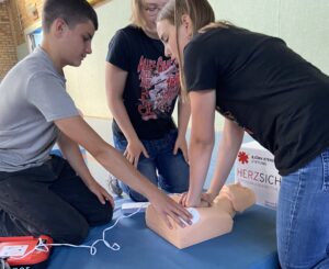 N&auml;chster Schritt im Reanimationsablauf: W&auml;hrend Hannah weiter die Herzdruckmassage durchf&uuml;hrt, legt Marlon die Elektroden des Trainingsdefibrillators an. Foto: Nannette Hoffmann