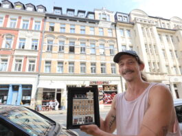 Miniaturk&uuml;nstler Schmii aka Andr&eacute; Schmidt steht mit seiner Miniatur vor dem Haus im Leipziger T&auml;ubchenweg. Foto: Dirk Knofe