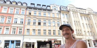 Miniaturk&uuml;nstler Schmii aka Andr&eacute; Schmidt steht mit seiner Miniatur vor dem Haus im Leipziger T&auml;ubchenweg. Foto: Dirk Knofe