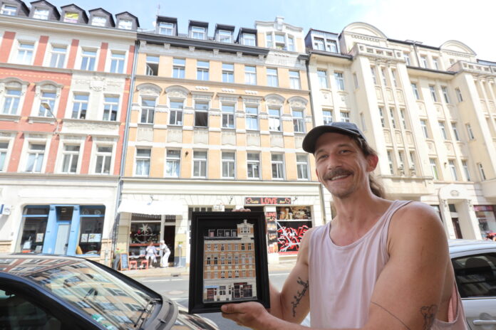 Miniaturkünstler Schmii aka André Schmidt steht mit seiner Miniatur vor dem Haus im Leipziger Täubchenweg. Foto: Dirk Knofe Miniaturkünstler Schmii aka André Schmidt steht mit seiner Miniatur vor dem Haus im Leipziger Täubchenweg. Foto: Dirk Knofe