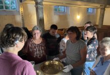Mit Interesse und Freude betrachten die Besucher des Werkstattabends die restaurierte Taufschale von Laue &ndash; ein wichtiges Kulturgut, das f&uuml;r kommende Generationen erhalten bleiben konnte. Foto: Nannette Hoffmann