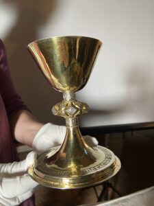 Der goldene Abendmahlskelch aus Zschernitz: Restauratorin Christina Neubacher präsentiert das Schmuckstück mit seiner kostbaren Vergoldung, das nach der Restaurierung in der Gemeinde wiederverwendet werden kann. Foto: Nannette Hoffmann
