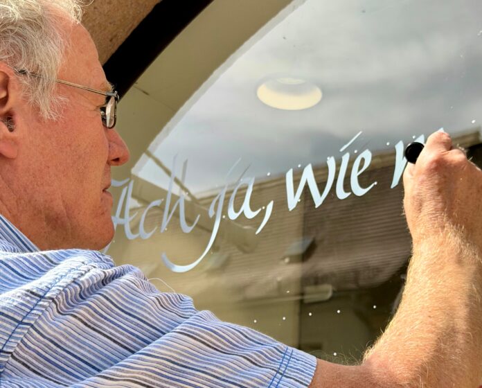 Frank Niemann schreibt Paul Gerhardt Texte an die Schaufenster. Foto: Sebastian Bachran