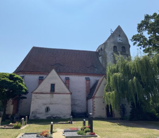 Die Kirche in K&ouml;lsa liegt ruhig neben dem Dorfteich. Auff&auml;llig ist ihr massiger runder Wehrturm. Foto: Nannette Hoffmann