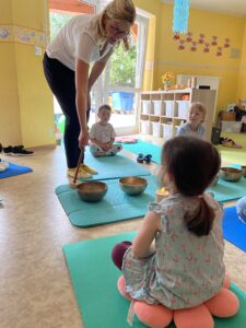 Susann Damisch spielt die Klangschalen an und die Kinder lauschen. Foto: Nannette Hoffmann