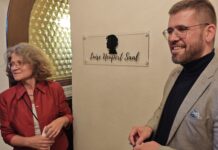 Angela Kiesewetter-Lorenz (Freundeskreis Scherenschnitt) und B&uuml;rgermeister Sven Schrade enth&uuml;llten das neue Schild f&uuml;r den Luise Neupert Saal. Foto: PM