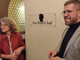 Angela Kiesewetter-Lorenz (Freundeskreis Scherenschnitt) und B&uuml;rgermeister Sven Schrade enth&uuml;llten das neue Schild f&uuml;r den Luise Neupert Saal. Foto: PM
