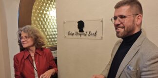 Angela Kiesewetter-Lorenz (Freundeskreis Scherenschnitt) und B&uuml;rgermeister Sven Schrade enth&uuml;llten das neue Schild f&uuml;r den Luise Neupert Saal. Foto: PM