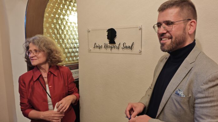 Angela Kiesewetter-Lorenz (Freundeskreis Scherenschnitt) und Bürgermeister Sven Schrade enthüllten das neue Schild für den Luise Neupert Saal. Foto: PM Angela Kiesewetter-Lorenz (Freundeskreis Scherenschnitt) und Bürgermeister Sven Schrade enthüllten das neue Schild für den Luise Neupert Saal. Foto: PM