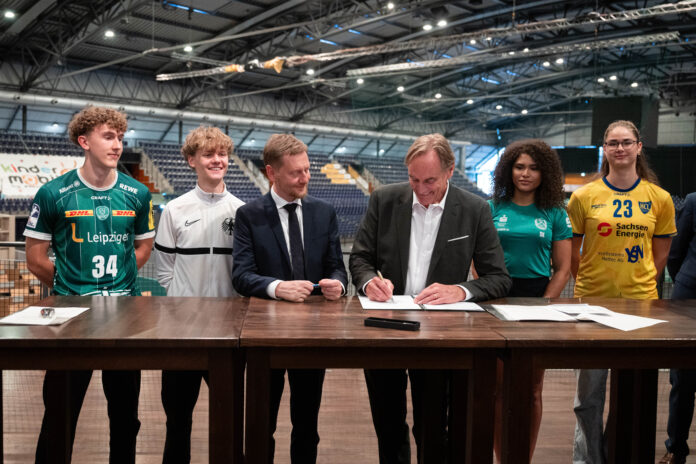 Anton Voß, Raban Crustewitz, Sachsens Ministerpräsident Michael Kretschmer, Leipzigs Oberbürgermeister Burkhard Jung, Sherin Kimuana, Marlene Tucholke (l-r) bei der Unterschrift Zuwendungsvertrag für neue Ballsporthalle in der Arena. Foto: Christian Modla Anton Voß, Raban Crustewitz, Sachsens Ministerpräsident Michael Kretschmer, Leipzigs Oberbürgermeister Burkhard Jung, Sherin Kimuana, Marlene Tucholke (l-r) bei der Unterschrift Zuwendungsvertrag für neue Ballsporthalle in der Arena. Foto: Christian Modla
